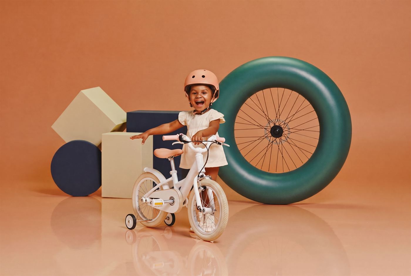 Peuter met helm op een zeegroene loopfiets in het park