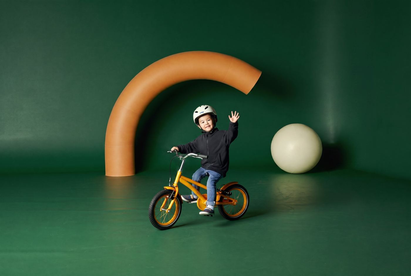 Kind van vijf leert fietsen op een zeegroene kinderfiets in een rustige straat