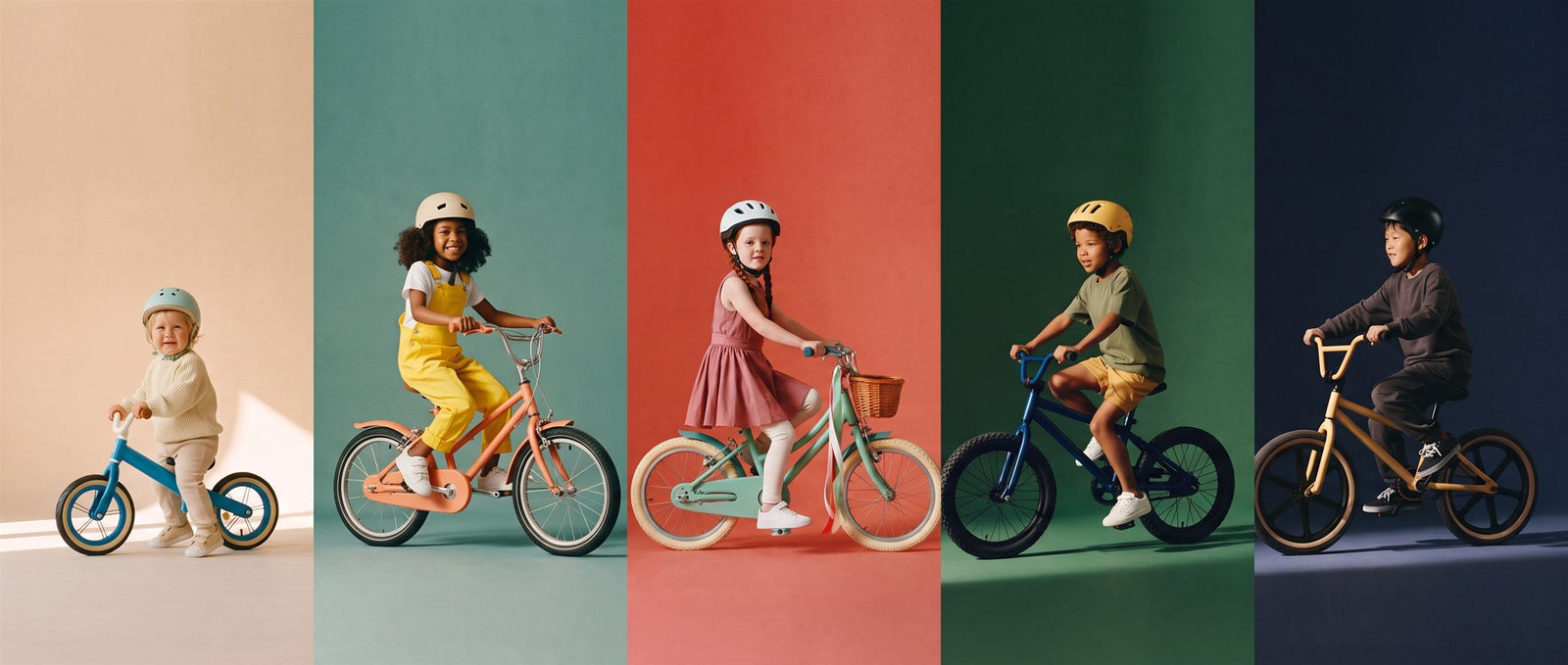 Vijf kinderen fietsen naast elkaar door vijf gekleurde studiobanen: van peuter op loopfiets tot jongen op BMX